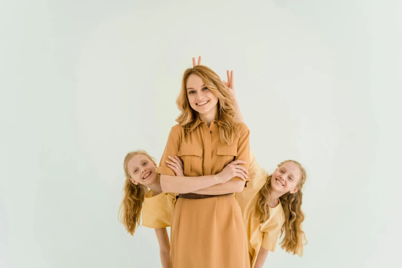 a woman and two young girls posing for a picture, pexels contest winner, brown shirt, symmetrical pose, avatar image, ginger hair