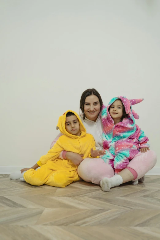 a woman and two children sitting on the floor, a picture, wearing a bunny suit, ameera al-taweel, 4 k image