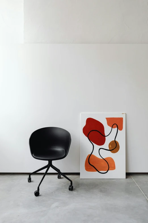 a black chair sitting next to a painting on a wall, poster art, inspired by Reinier Nooms, abstract art, orange and black, home office, dwell, flow shapes