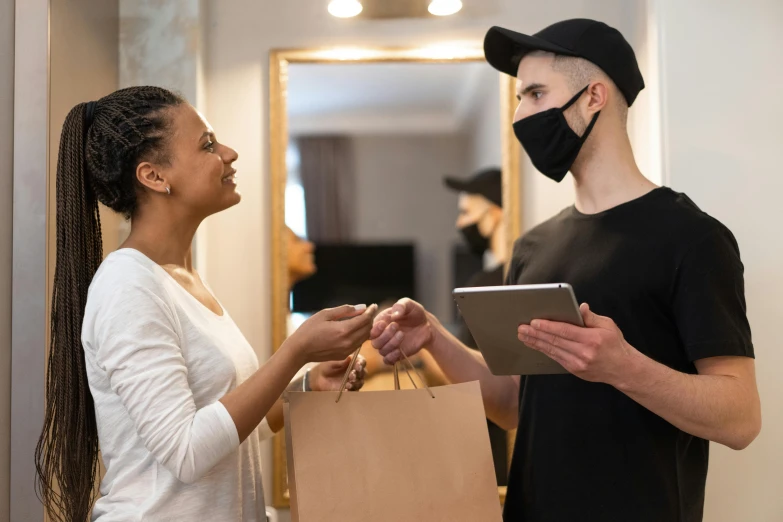 a man and a woman are looking at a tablet, pexels contest winner, white man with black fabric mask, delivering packages for amazon, lachlan bailey, decoration