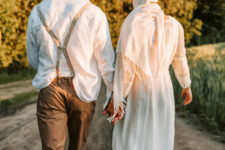 a man and a woman walking down a dirt road, trending on pexels, renaissance, white hijab, 1 9 2 0 s cloth style, white ribbon, wearing a linen shirt