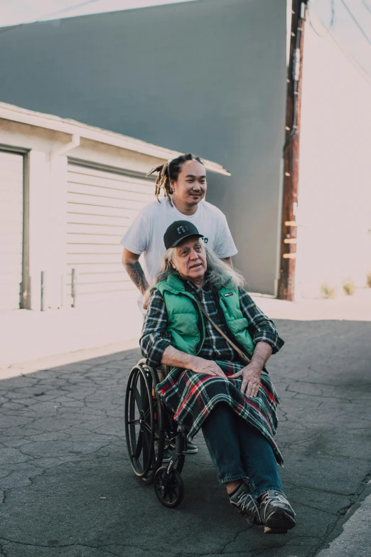 a man standing next to a woman in a wheelchair, an album cover, unsplash, danny trejo, neighborhood, yung lean, los angelos