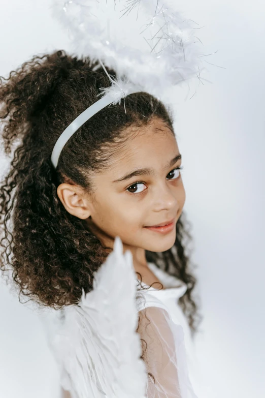 a little girl wearing a white angel costume, inspired by Marie Angel, willow smith young, liberty curls, award-winning, for junior