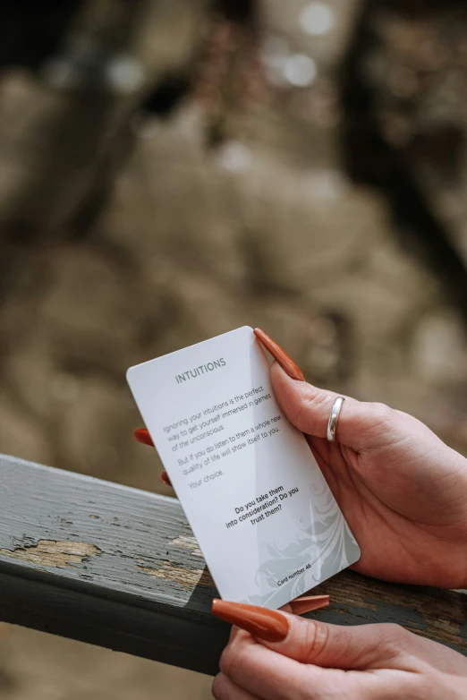 a close up of a person holding a piece of paper, deck, in nature, instructions, whole card