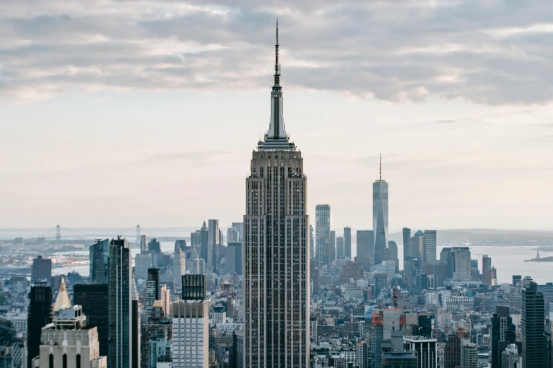 the empire state building towering over the city of new york, unsplash contest winner, neoclassicism, 2000s photo, tall thin build, ad image