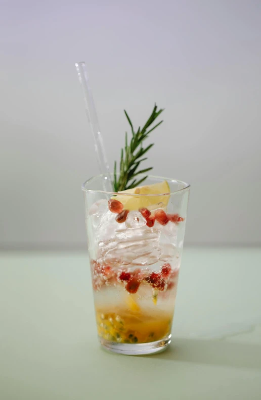 a close up of a drink in a glass on a table, infused, sprigger, pomegranate, multi-dimensional