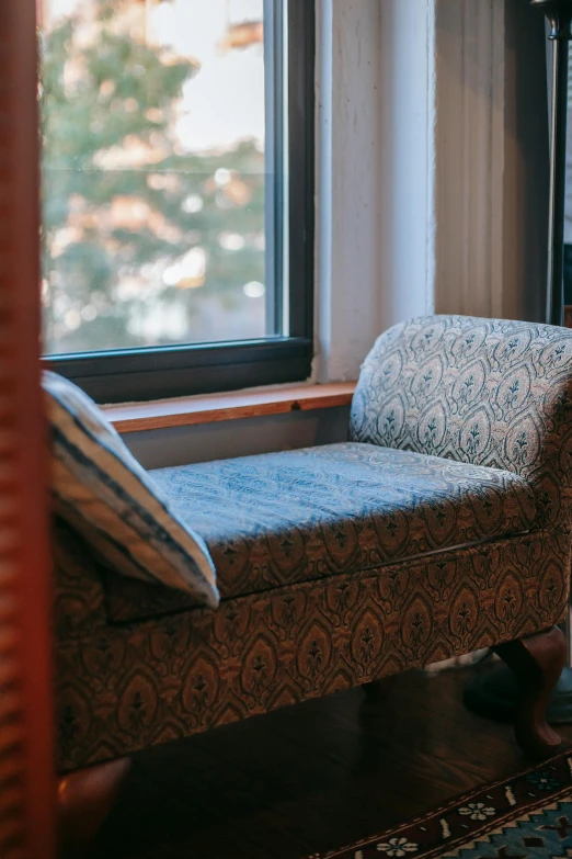 a chair sitting in front of a window next to a lamp, bay window sofa, resting on chest, waiting room