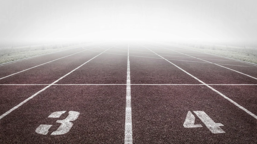 a black and white photo of a running track, pexels contest winner, fog on ground, brightly lit, stylized illustration, split in half