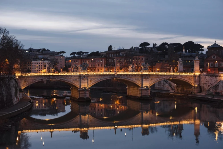 a bridge over a river with buildings in the background, by Cagnaccio di San Pietro, pexels contest winner, neoclassicism, evening lights, panoramic, olafur eliasson, profile image