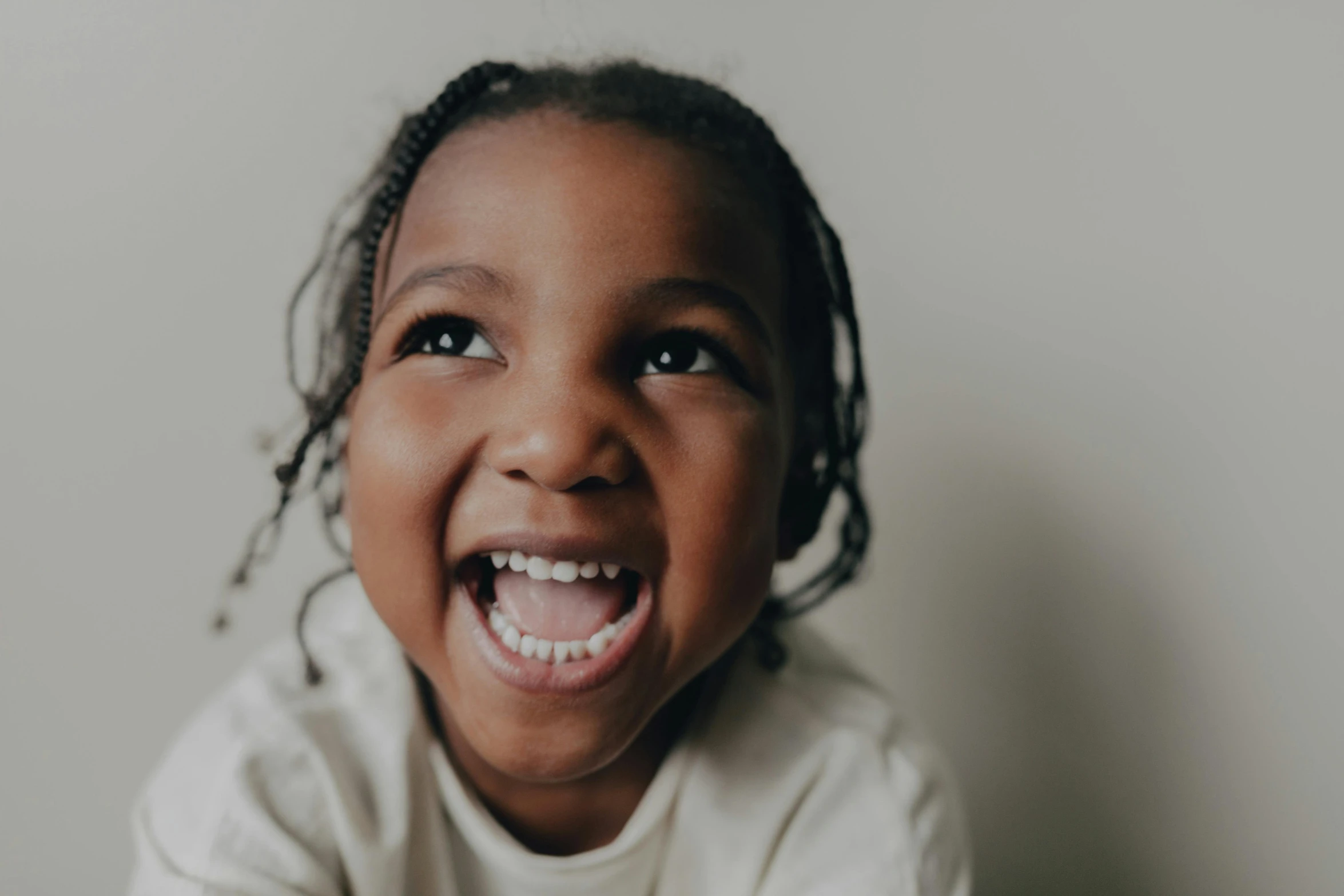 a little girl with a big smile on her face, a picture, by Lee Loughridge, pexels contest winner, hurufiyya, plain background, looking upward, ryan kiera armstrong, riyahd cassiem