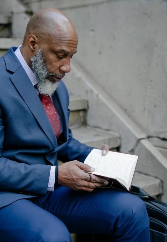 a man in a suit reading a book, inspired by William H. Mosby, pexels, renaissance, grey skinned, sitting on temple stairs, 50 years old men, profile image