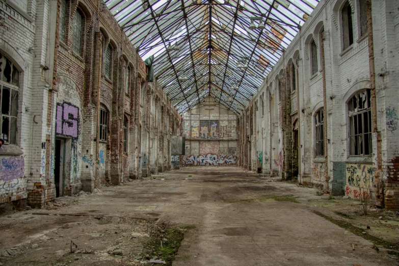 an old building with graffiti all over it, pexels contest winner, large glass ceilings, land of ruins, ((rust)), coloured photo