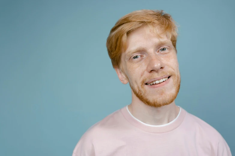 a close up of a person wearing a pink shirt, trending on pexels, hyperrealism, ginger hair, smiling male, pale bluish skin, high quality image
