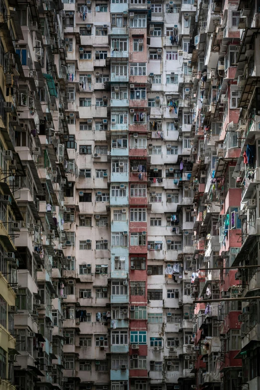 a very tall building with lots of windows, by Patrick Ching, unsplash contest winner, hyperrealism, kowloon walled city, crenellated balconies, massive crowd, greebles