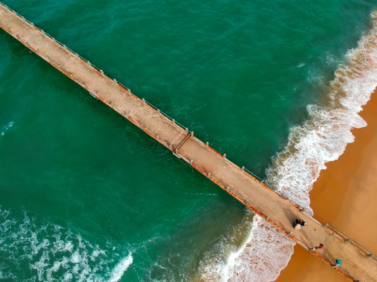 a bridge over a body of water next to a beach, pexels contest winner, hurufiyya, copper and emerald, south african coast, brown, bird's eye