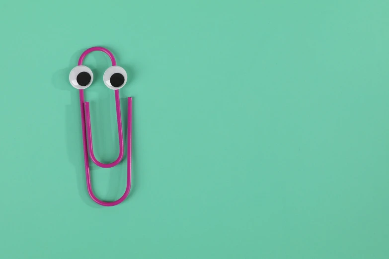 a pink paper clip with googly eyes on a green background, trending on pexels, speculum, teacher, long nose, brightly coloured
