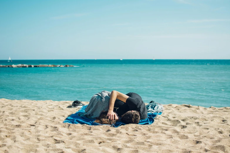 a man laying on top of a beach next to the ocean, by Julia Pishtar, pexels contest winner, couple kissing, covered with blanket, summer weather, manly