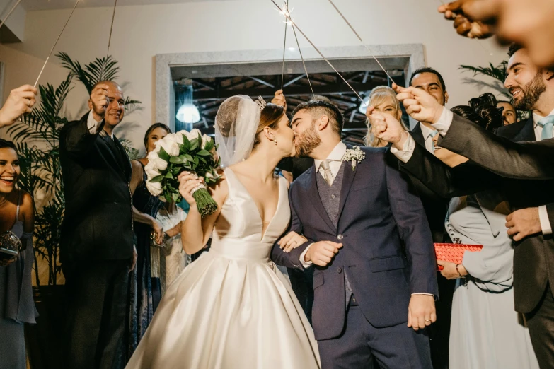 a bride and groom kiss as they walk down the aisle, pexels contest winner, puerto rico, thumbnail, leaving a room, a group of people