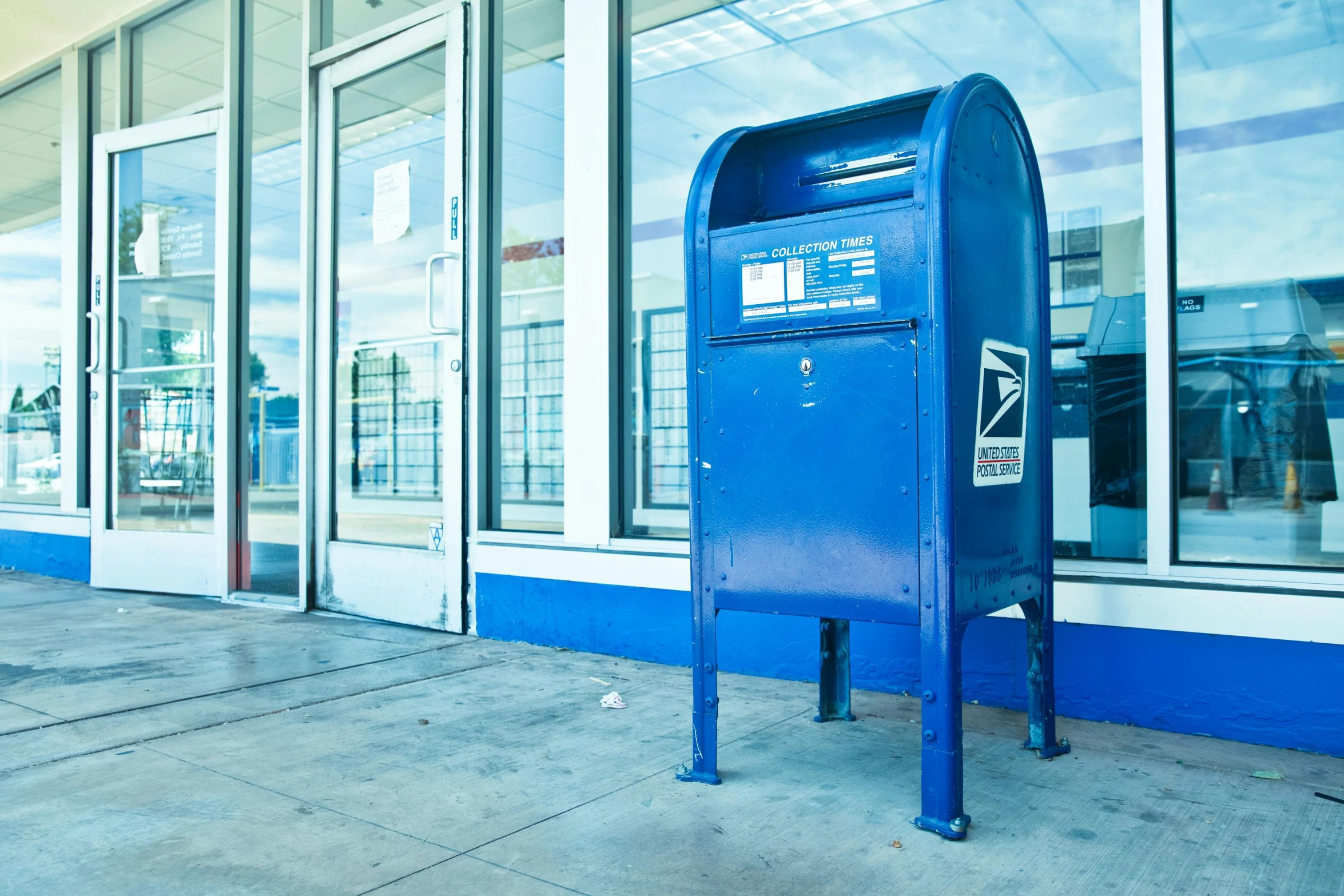 a blue mail box sitting in front of a building, by Washington Allston, unsplash, private press, los angeles ca, ignant, postage, a hyper realistic