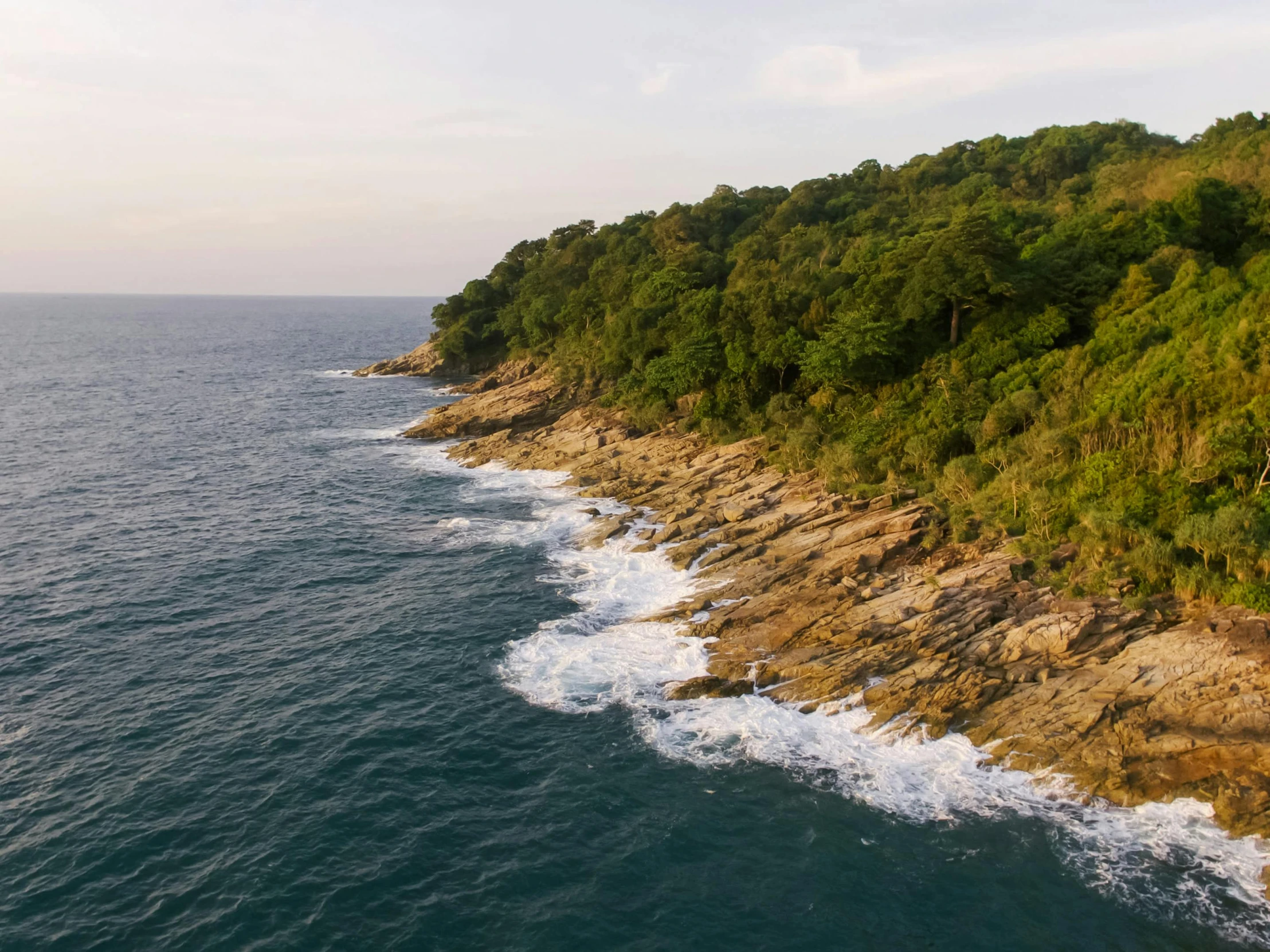 a large body of water next to a forest, a digital rendering, pexels contest winner, sumatraism, ocean cliff side, thailand, offshore winds, real engine 5 cinematic