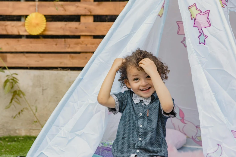 a little boy that is sitting in a teepee, pexels contest winner, she is smiling and excited, a unicorn, tent architecture, flattened