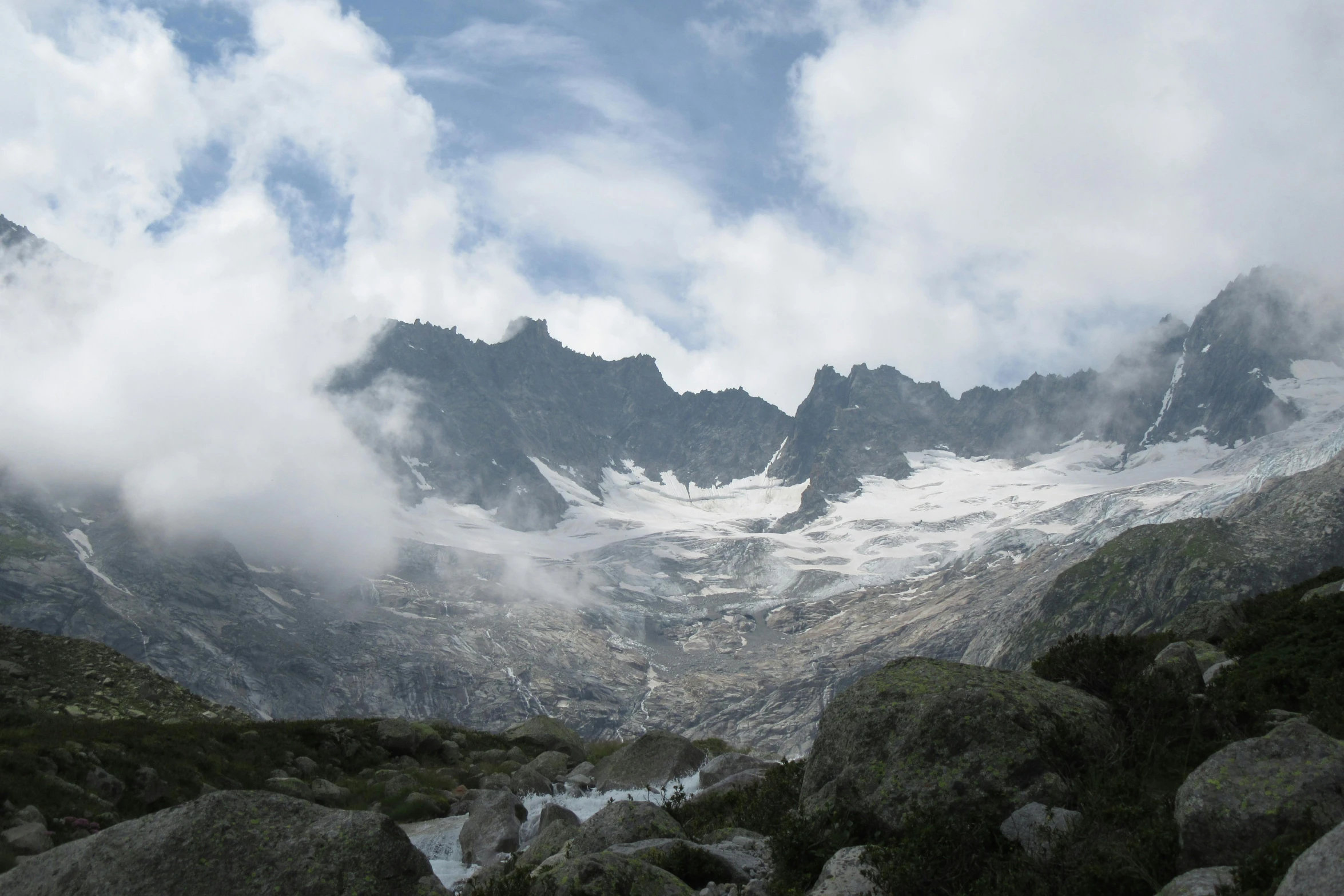 a large mountain covered in snow and clouds, by Werner Andermatt, pexels contest winner, les nabis, waterfalls in distance, glacier, 2000s photo, fan favorite