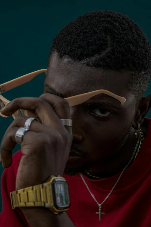 a man in a red shirt holding a pair of scissors, an album cover, trending on pexels, visual art, rapper jewelry, eyes wide, baptiste from overwatch, shot with sony alpha 1 camera