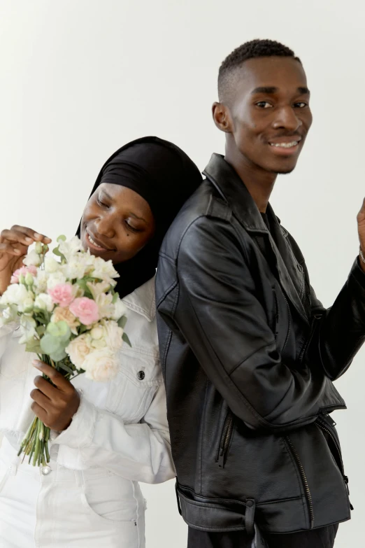 a man standing next to a woman holding a bouquet of flowers, trending on unsplash, somali attire, lesbians, plain background, white and black clothing