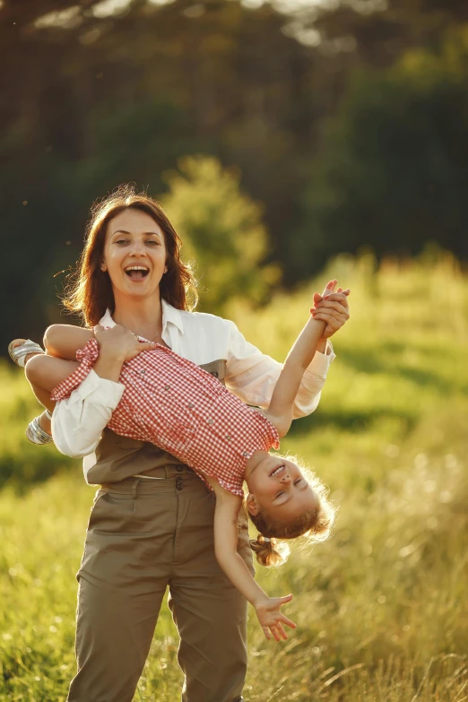 a woman holding a child in a field, having fun in the sun, square, stockphoto, digital image