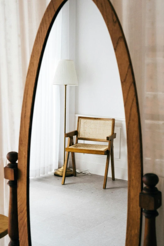 a wooden chair sitting in front of a mirror, inspired by Constantin Hansen, unsplash, renaissance, floor lamps, arched back, with a white background, door