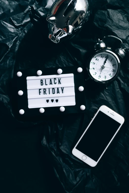 a black friday sign sitting on top of a table next to a phone, by Julia Pishtar, trending on unsplash, flat lay, thumbnail, show, profile image