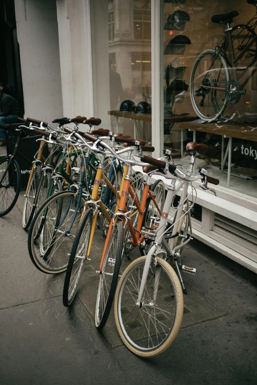 a row of bicycles parked in front of a store, by Nina Hamnett, unsplash, london, manhattan, brown, various colors