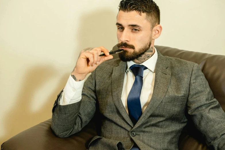 a man in a suit smoking a cigarette, zachary corzine, relaxing, short brown beard, thumbnail