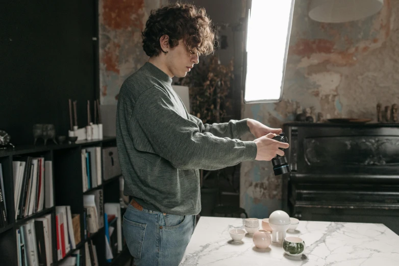 a man that is standing in front of a table, a photorealistic painting, pexels contest winner, with anamorphic lenses, ceramics, photoshoot for skincare brand, holding a candle holder