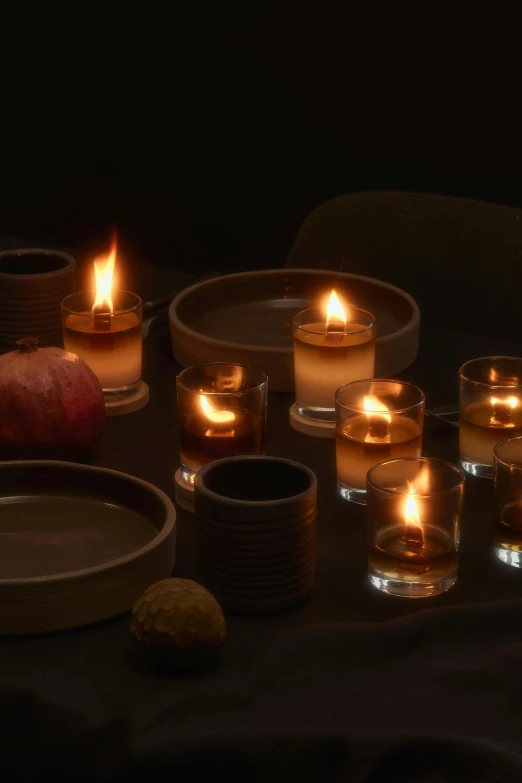 a group of candles sitting on top of a table, a still life, inspired by Einar Hakonarson, ceramic, dark hues, warm coloured, 4l