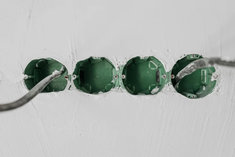 a close up of a bunch of electrical wires, inspired by Lucio Fontana, trending on pexels, plasticien, portholes, emerald, recessed, detailed product image