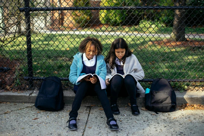 two girls sitting on a bench reading books, trending on unsplash, ashcan school, schomburg, full shot photograph, getty images, aida muluneh