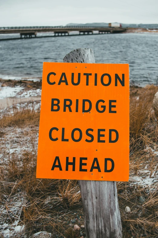 a close up of a sign near a body of water, by Matt Cavotta, pexels, broken bridges, 2 5 6 x 2 5 6 pixels, cone, multiple stories