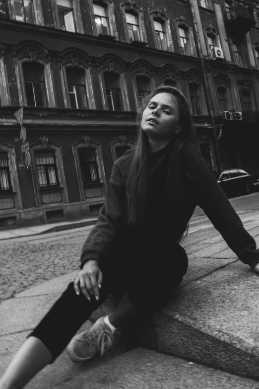 a black and white photo of a woman sitting on a curb, inspired by irakli nadar, tumblr, beautiful young ornella muti, 15081959 21121991 01012000 4k, in a square, andrey tarkovsky