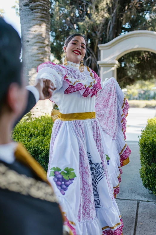 a man standing next to a woman in a white dress, happening, folklorico, waving robe movement, wine, prima ballerina in rose garden