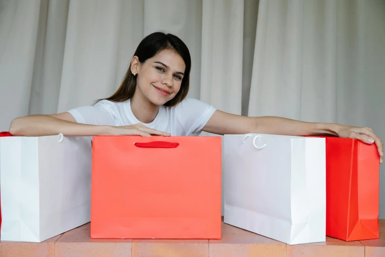 a woman holding two red and white shopping bags, pexels contest winner, avatar image, malaysian, thumbnail, satisfied pose