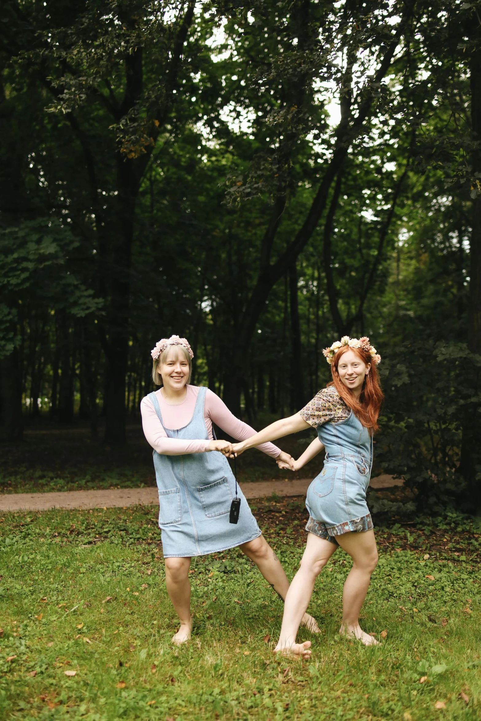 a couple of women standing on top of a lush green field, an album cover, by Zofia Stryjenska, pexels contest winner, dancing a jig, in the wood, 35mm of a very cute, very silly looking