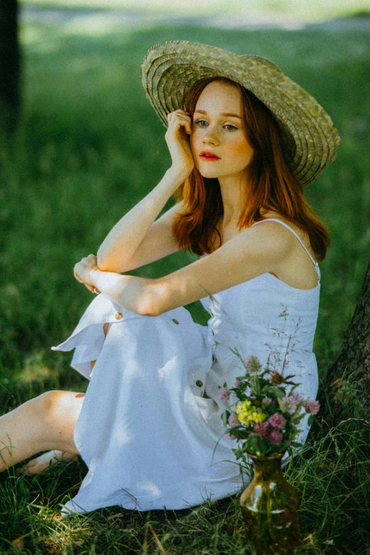 a woman sitting under a tree in a white dress and straw hat, inspired by Konstantin Somov, pexels contest winner, ( redhead, handsome girl, bouquet, julia sarda