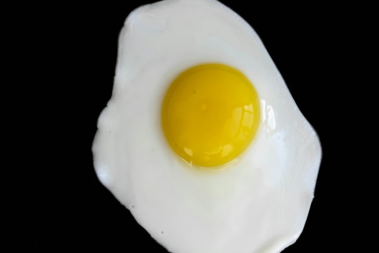 a fried egg sitting on top of a white plate, a photo, unsplash, hurufiyya, on black background, 15081959 21121991 01012000 4k