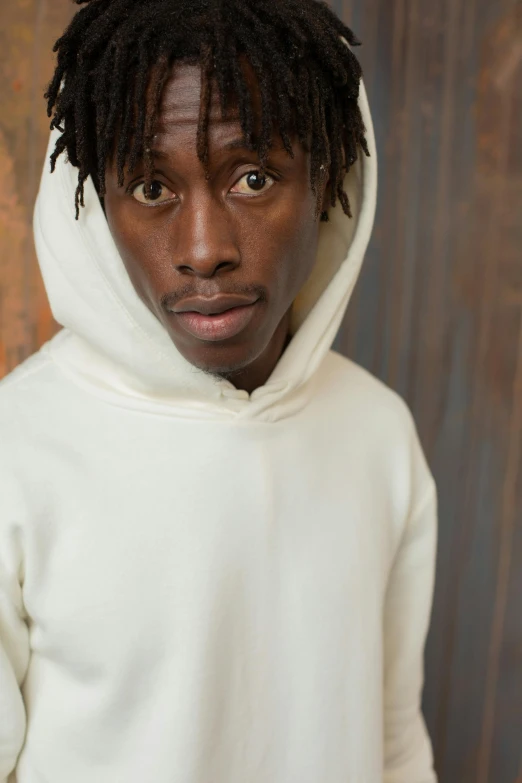 a man with dreadlocks wearing a white hoodie, trending on pexels, adut akech, 2 1 savage, corduroy, ignant