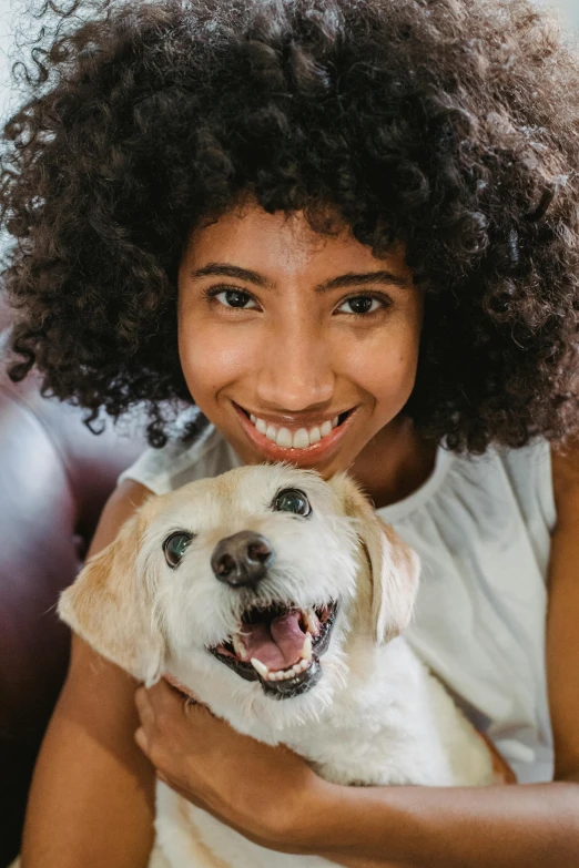 a woman sitting on a couch holding a dog, pexels contest winner, renaissance, brown skin man with a giant grin, closeup of an adorable, ashteroth, thumbnail