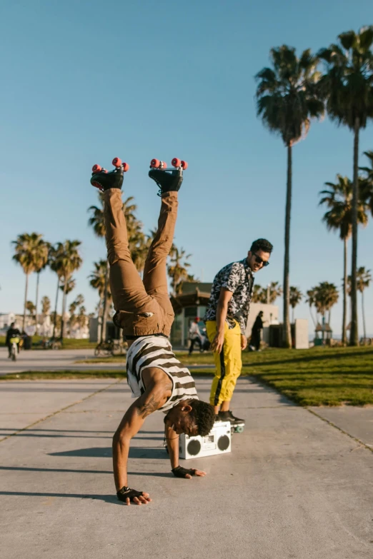 a person doing a handstand on a skateboard, pexels contest winner, two young men, a palm tree, hey buddy, rollerskaters