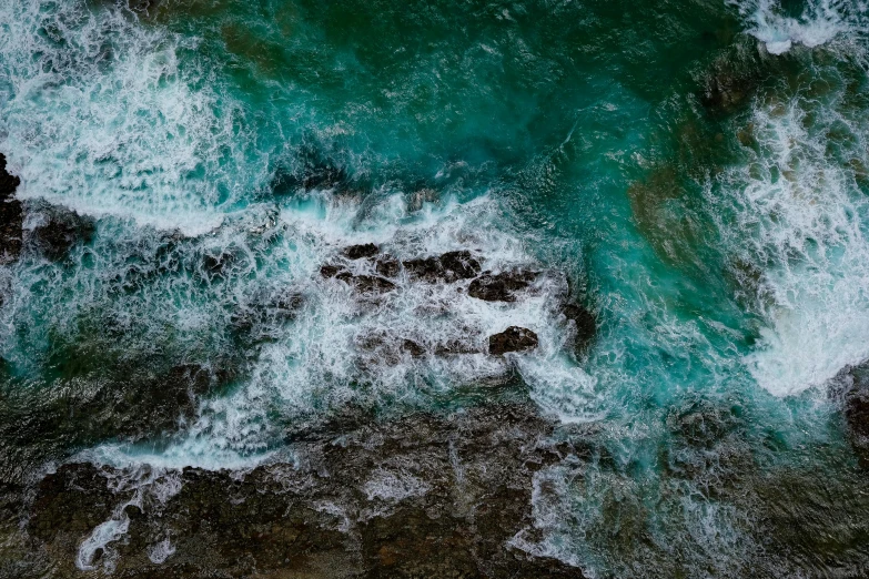 an aerial view of a body of water, inspired by Elsa Bleda, pexels contest winner, hurufiyya, waves crashing at rocks, teal energy, looking threatening, 4 k hd wallpapear