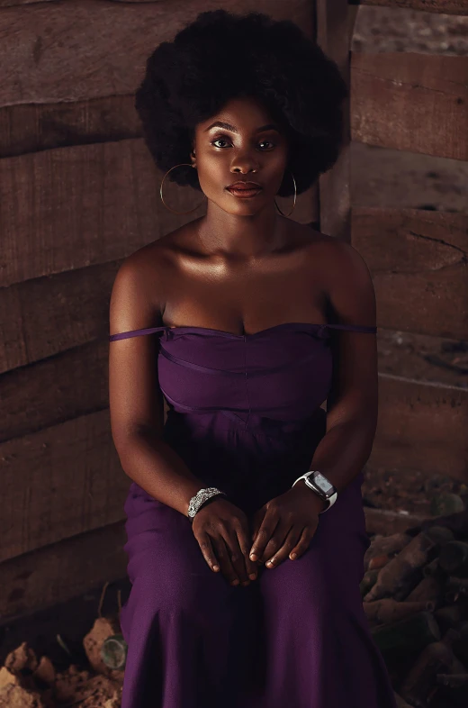 a woman in a purple dress posing for a picture, an album cover, by Chinwe Chukwuogo-Roy, pexels contest winner, seated on wooden chair, afro, intense look, promotional image