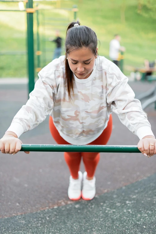 a woman doing pull ups in a park, by Arabella Rankin, camo, wearing a track suit, playground, hyperedetailed photo